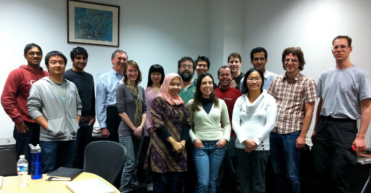 A group of men and women pose in a conference room.
